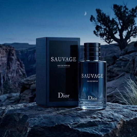 Dior Sauvage Eau de Parfum 100ml bottle beside its black box on a rock at dusk